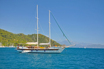 Fototapeta premium The ship on the background of the bright blue Mediterranean sea and the mountains
