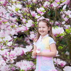Child with magnolia flower. Little girl with flowers © famveldman