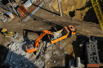 excavator moving earth and unloading into a dumper truck