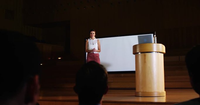 Audience applauding speaker before conference presentation