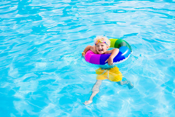 Child with toy ring in swimming pool