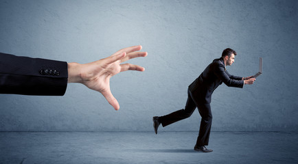 Businessman running from hand