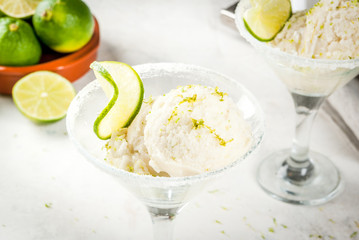 Homemade salted lemon lime ice cream sherbet. Margarita ice cream. With lime and zest, in glasses with salt decor and snack of lime slice.