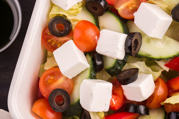 Salad an iceberg with cheese feta, sauce, cucumbers and olives