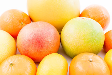 Fresh lemon, orange, mandarin, grapefruit, sweetie and pomelo fruits on white background. Flat lay, top view.