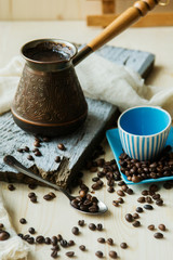 Coffee cup and metal turk on burlap background