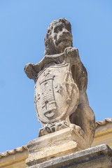 Fototapeta na wymiar Stone lion on the facade Hospital de Santiago, Ubeda, Jaen, Spain