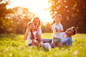 Family with children blow soap bubbles