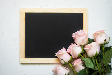 Bouquet of Pink rose and chalkboard at white stone table. Mothers day