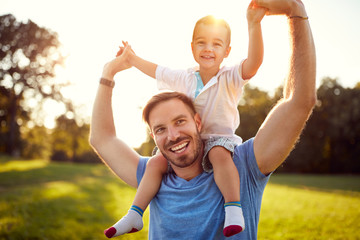 Happy father with son in park - obrazy, fototapety, plakaty