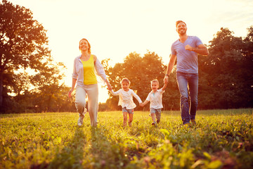 Happy family run on green field