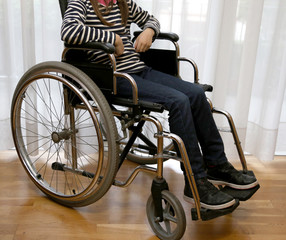 Obraz premium young disabled child in a wheelchair in her bedroom