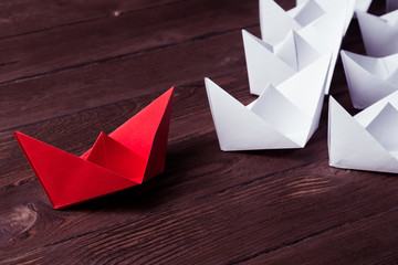 Business leadership concept with white and color paper boats on 