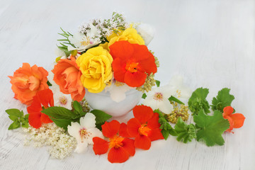 Medicinal Flowers and Herbs. With nasturtium, rose, elderflower, ladies mantle, orange blossom, marjoram, mint and angelica seed heads used in natural herbal medicine.