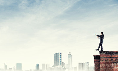 Danger and risk concept with businessman making step from edge