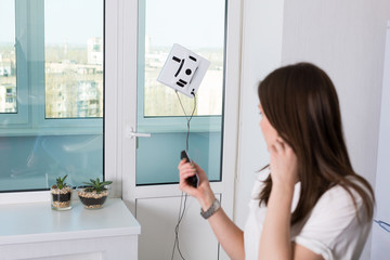 Woman cleaning windows with robotic cleaner