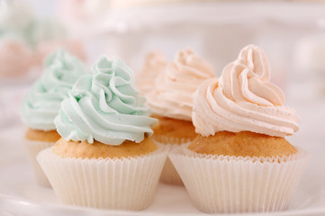 Plate with tasty cupcakes on table, closeup