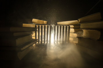 Many old books in a stack. Knoledge concept. Books on a dark background with smoke elements. Bewitched book in center