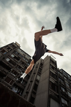 young man doing parkour jump in the city