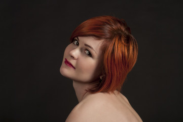 Portrait of a smiling girl on a dark background.