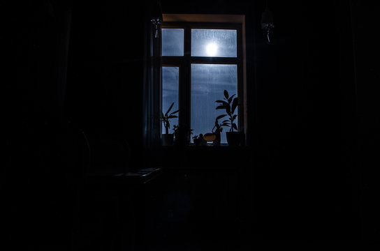 Night scene of moon seen through the window from dark room