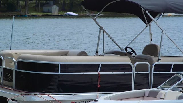 Anchored Boat Near Dock Bobbing on Lake During Cloudy Summer Day