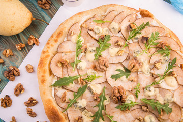 Dessert pizza with a pear and lemon oil, walnut and crude Dorblu