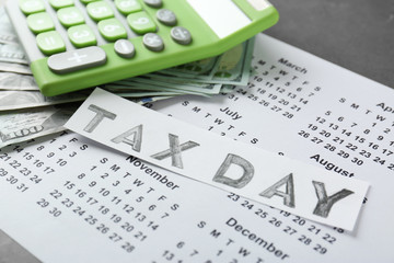 Green calculator and money on calendar. Tax concept
