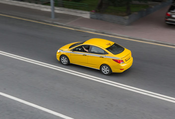 Fototapeta na wymiar yellow taxi moves on the city