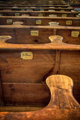 Church benches. Interior of old middle age church - benches with ancient names labels - narrow...
