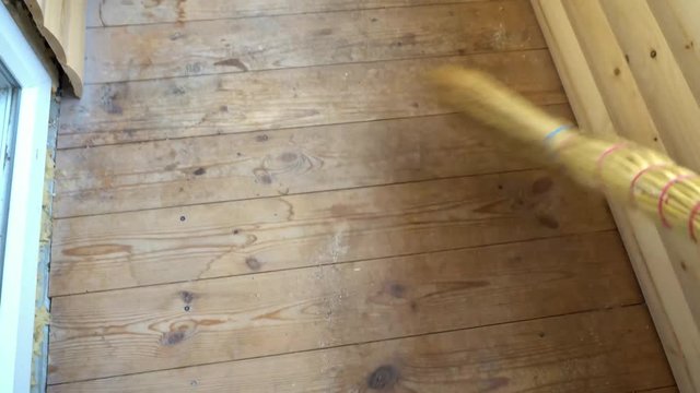 man sweeping the wooden floor,side view.
