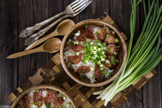 Rice with bacon and green onions. Nourishing lunch for two in clay dishes