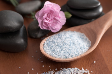 Fototapeta na wymiar Composition of spa treatment. Spoon of sea salt and stones for massage