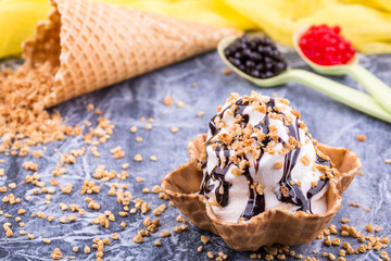 An ice cream basket with chocolate jam, sprinkled shredded nuts
