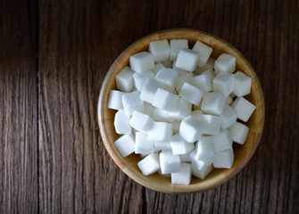 Fototapeta na wymiar Sugar cubes in wood bowl on wood table