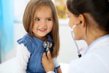 Doctor examining a little girl by stethoscope