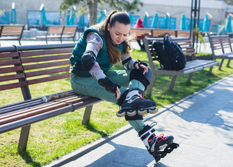 Beautiful young roller girl unscrewing wheels on freeskate roller Skates with Allen key or Hex key...