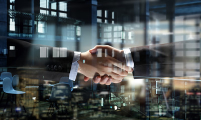 Partners shaking hands as symbol of deal . Mixed media