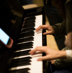 Two People Playing Piano Together