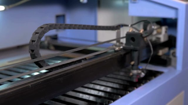 The carriage on the laser machine moves during operation