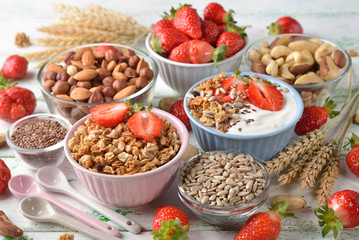 Muesli, nuts, yogurt and cereals on a white background