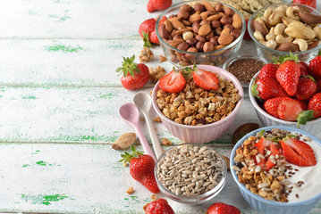 Muesli, nuts, yogurt and cereals on a white background
