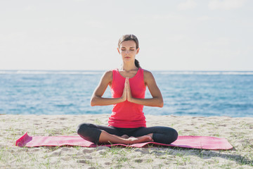 Fototapeta na wymiar sporty young woman doing yoga meditation at the beach