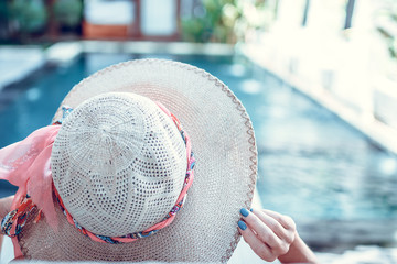 Young woman in swimsuit in swimming pool in gorgeous resort, luxury villa, tropical Bali island, Indonesia.