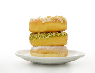 three variant donuts stacked on white plate