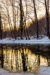 Scenery of wild river with sunset sky reflection in the mountains, in winter