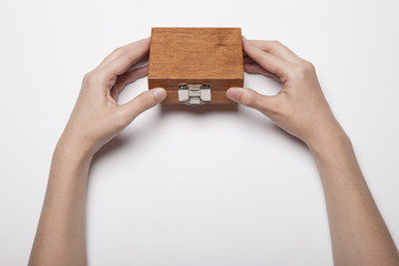 woman hand hold a wood case(package) isolated white.