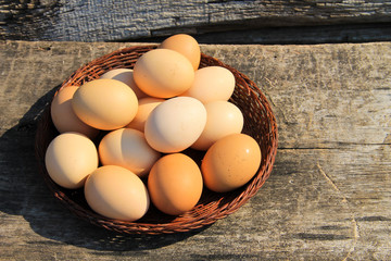 Eggs in wicker basket on wooden table