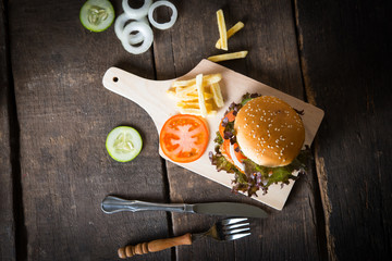 Top view of Rustic homemade hamburger and french fries with tomato sauce.