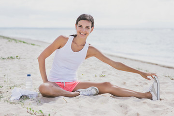 Fototapeta na wymiar happy healthy woman smiling while doing leg stretching